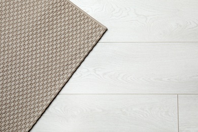 Photo of Woven mat on wooden background, top view with space for text