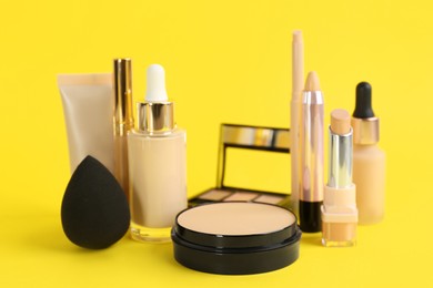 Foundation makeup products on yellow background. Decorative cosmetics