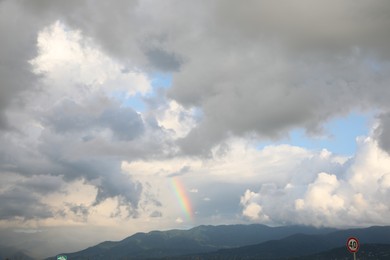 Photo of Picturesque view of sky with heavy rainy clouds and rainbow