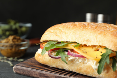 Photo of Delicious sandwich with fresh vegetables and cheese on grey table, closeup