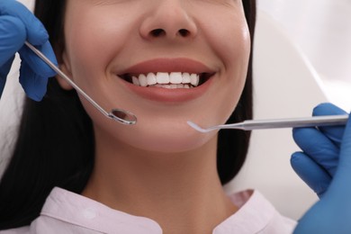 Dentist examining young woman's teeth, closeup view