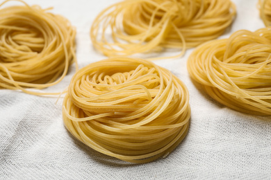 Capellini pasta on white tablecloth, closeup view