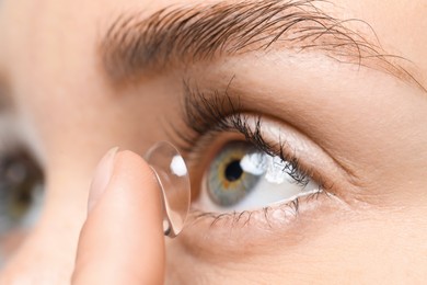 Photo of Woman putting in contact lens, closeup view