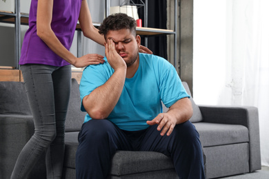 Woman comforting her depressed overweight friend at home