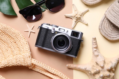 Flat lay composition with retro camera and sunglasses on color background