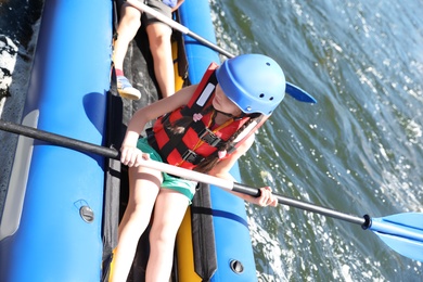 Photo of Little girl kayaking on river. Summer camp