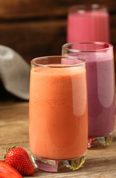 Glasses with tasty smoothies on wooden table