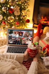 Young woman having online meeting with family members via videocall application at home, closeup