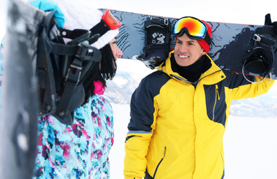 Lovely couple with snowboards on hill. Winter vacation