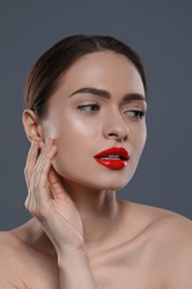 Young woman with red lips makeup on grey background