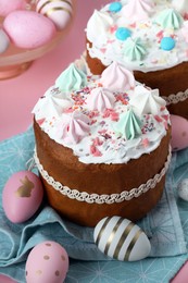 Photo of Traditional Easter cakes with meringues and painted eggs on pink background