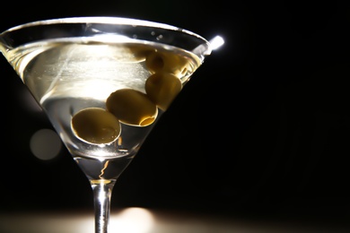 Glass of martini with olives in bar, closeup. Space for text