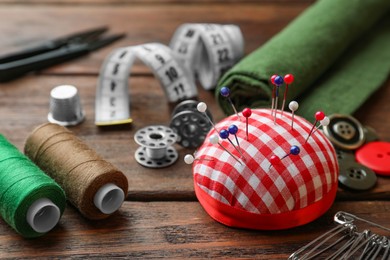 Photo of Threads and other sewing supplies on wooden table, closeup