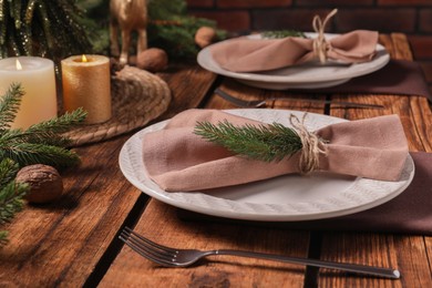 Photo of Festive place setting with beautiful dishware, cutlery and fabric napkin for Christmas dinner on wooden table