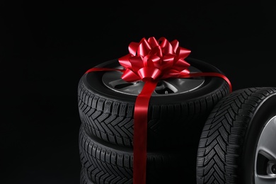 Gift set of wheels with winter tires on black background, closeup