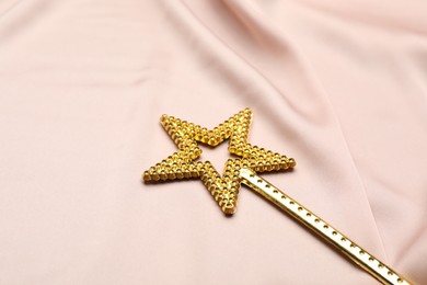 Beautiful golden magic wand on pink fabric