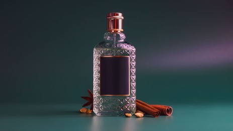 Photo of Bottle of luxurious perfume and spices on color background