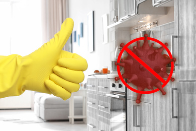 Image of Keep your home virus-free. Woman showing thumb up in clean kitchen