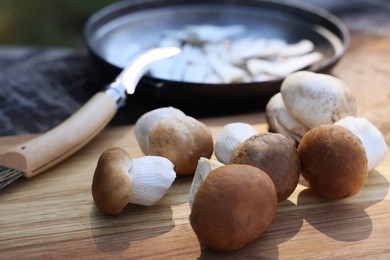 Fresh mushrooms on wooden table outdoors, closeup