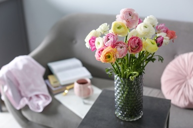 Bouquet of beautiful ranunculuses on table in living room. Space for text