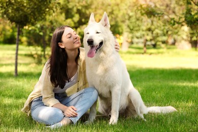 Teenage girl with her white Swiss Shepherd dog in park