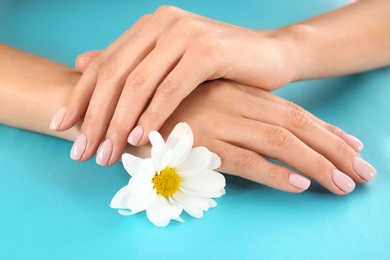Closeup view of woman with flower on color background. Spa treatment