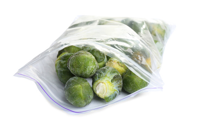 Frozen Brussels sprouts in plastic bag isolated on white. Vegetable preservation