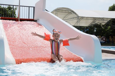 Cute little girl on slide in water park