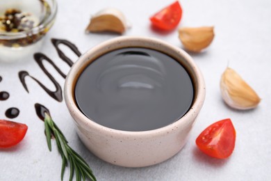 Photo of Organic balsamic vinegar and cooking ingredients on white table, closeup