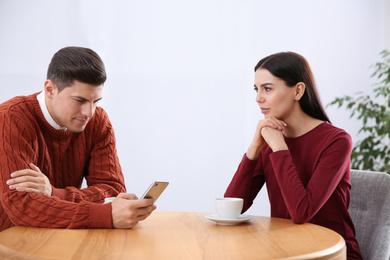 Man preferring smartphone over his girlfriend in cafe. Relationship problems