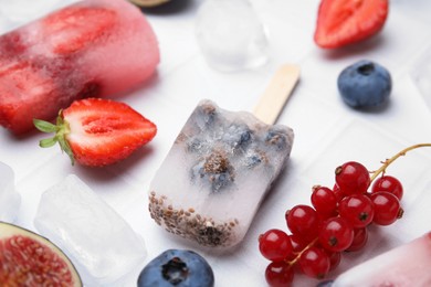 Photo of Tasty refreshing berry ice pops on white table, closeup