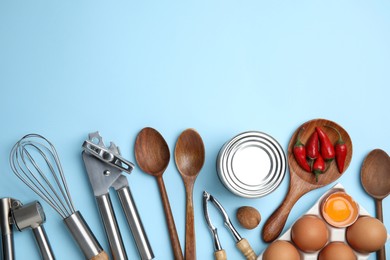 Cooking utensils and ingredients on light blue background, flat lay. Space for text