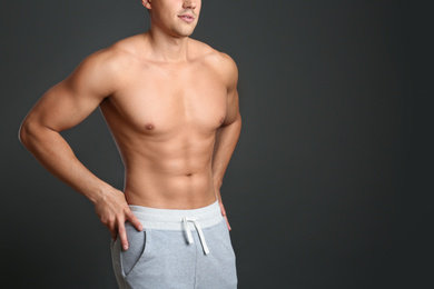 Man with sexy body on grey background, closeup. Space for text
