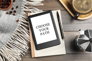 Tablet with phrase Choose Your Path, notebook and coffee on wooden table, flat lay