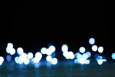 Blurred view of beautiful lights on black background. Bokeh effect
