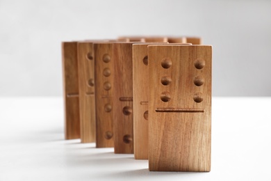 Beautiful wooden dominoes on white table, closeup