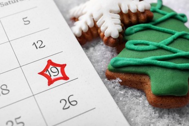 Saint Nicholas Day. Calendar with marked date December 19 and gingerbread cookies on snow, closeup