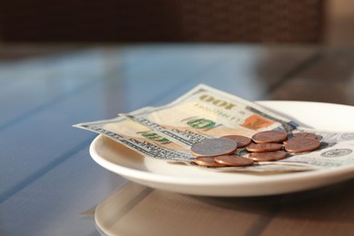 Photo of Saucer with payment for order on table, closeup. Leave tip