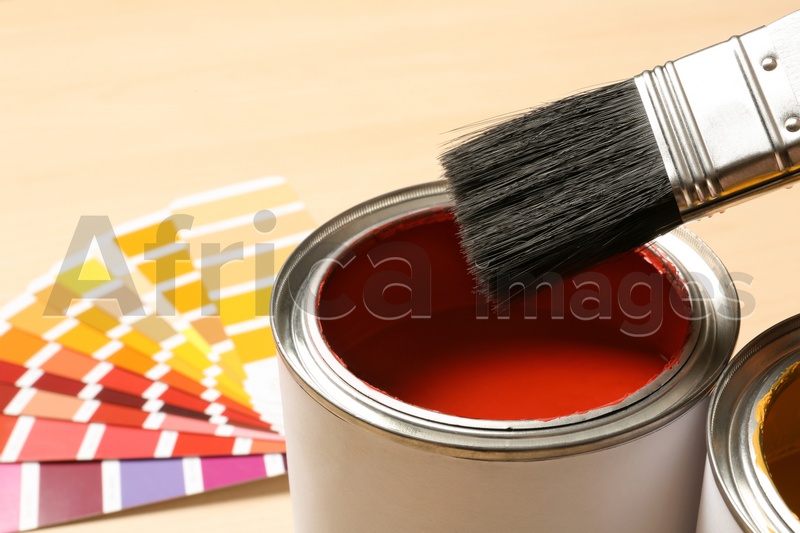 Red paint can, brush and color palette on table, closeup. Space for text