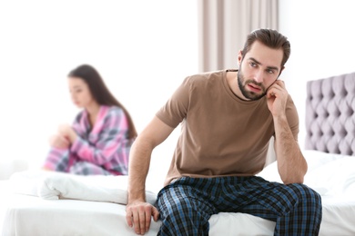Young couple ignoring each other after having argument in bedroom