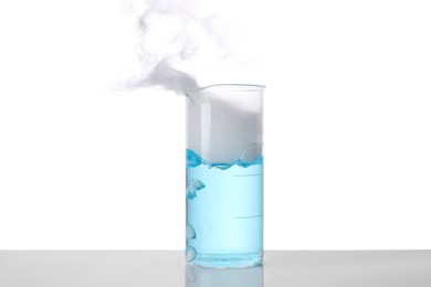 Photo of Laboratory beaker with light blue liquid and steam isolated on white. Chemical reaction