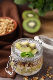 Photo of Delicious dessert with kiwi and chia seeds on brown table, closeup