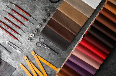 Flat lay composition with leather samples and craftsman tools on grey stone background