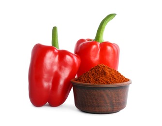 Fresh bell peppers and bowl of paprika powder on white background