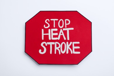 Sign with phrase Stop Heat Stroke on white background, top view