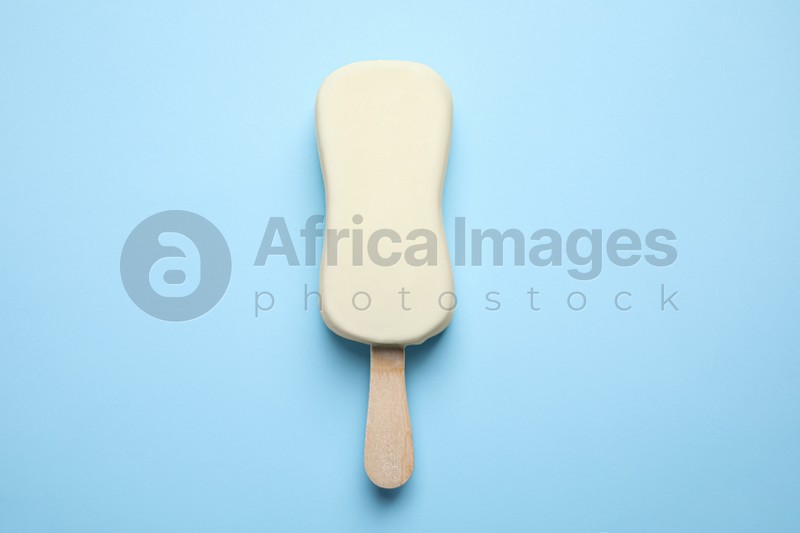 Photo of Ice cream with glaze on light blue background, top view