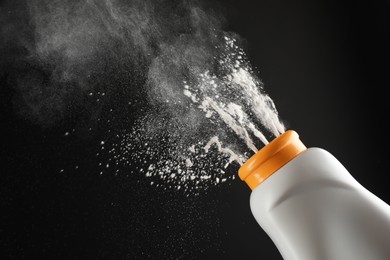 Photo of Scattering of dusting powder on black background