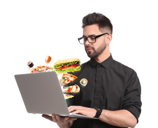 Young man using laptop for ordering food online on white background. Delivery service during quarantine