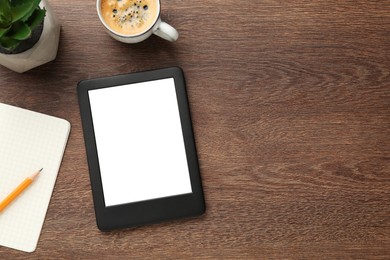 Modern ebook reader, plant, coffee and notebook on wooden table, flat lay. Space for text