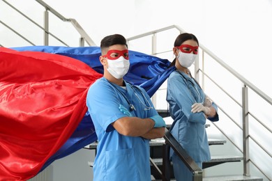 Doctors dressed as superhero in hospital. Concept of medical workers fighting with COVID-19